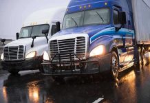 DMV Error WIPES OUT Thousands Of Careers Two trucks driving on a wet road.