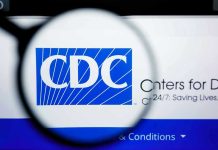 Newborns Lose Shield After Stunning CDC Reversal CDC logo magnified on a screen.