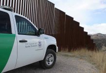 Why Border Issues Keep Getting Ignored in Senate Border protection vehicle near a large metal fence.