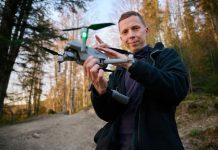 Drone Drops LUXURY Feast Into Prison Yard Person holding a drone in a forest.
