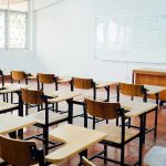 Why Single-Sex Education Is Being Reconsidered Empty classroom with desks, chairs, and whiteboard.