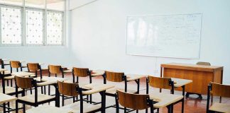 Why Single-Sex Education Is Being Reconsidered Empty classroom with desks, chairs, and whiteboard.