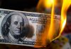 Shocking Misuse of COVID Funds Uncovered Burning hundred-dollar bill with visible flames.