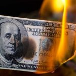 Shocking Misuse of COVID Funds Uncovered Burning hundred-dollar bill with visible flames.