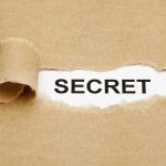 Rising Democrat Star’s Hidden Stock Scandal A torn piece of brown paper revealing the word SECRET underneath