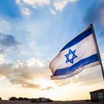 Controversial Swastika Display Outrages Jewish Groups Israeli flag waving against a sunset backdrop with clouds