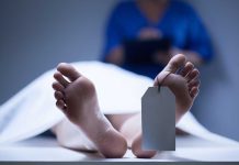 Quebec’s SHOCKING 7.2% Euthanasia Rate – World’s Highest! A deceased body on a table with a tag on the foot, and a medical professional in the background