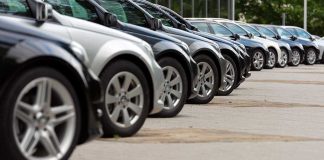 A row of parked black and silver cars in a dealership