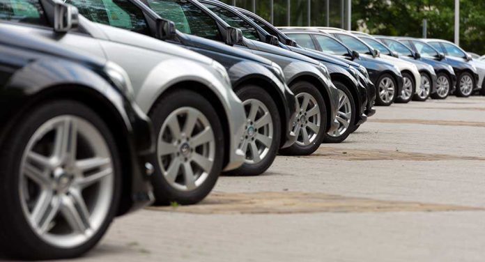 shutterstock_227900236.jpg A row of parked black and silver cars in a dealership