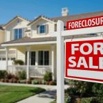 The Housing Crisis Has Official ‘Villain’ Now Foreclosure sign in front of a house for sale