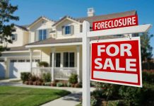 The Housing Crisis Has Official ‘Villain’ Now Foreclosure sign in front of a house for sale