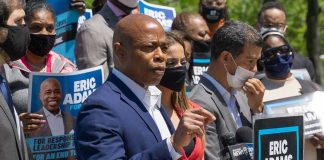 NYC Mayor ERASES Eric Adams’ Orders Overnight Man speaking at campaign event with supporters behind him.
