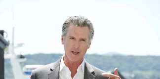 $70B Fraud Scandal EXPLODES! Man speaking with microphone outdoors.