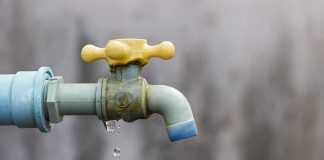 Close-up of a dripping outdoor water faucet