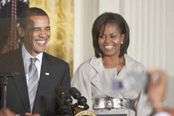 Former President Barack Obama and Michelle Obama smiling at a public event