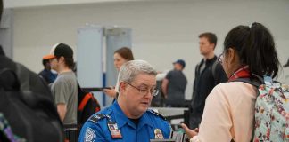 Mom Smuggles Chicken Past TSA TSA agent checks passengers documents at airport security.