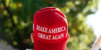 MAGA Civil War Over Iran War Person wearing a red Make America Great Again hat.