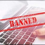 Red Banned stamp over a laptop keyboard.