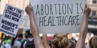 Protestors holding signs about womens rights and healthcare.