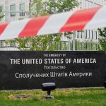 Netanyahu BLASTS Social Media Manipulation U.S. Embassy sign behind red-and-white caution tape.