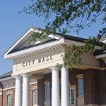Shocking Betrayal: Mayor Caught As Chinese Agent Exterior view of a city hall building with columns and a clear blue sky