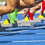 Is Sports Fairness Dead? Transgender Controversy Erupts Athletes starting a sprint from starting blocks on a blue track