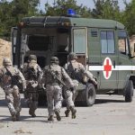 IDF Listed For Sexual Crimes By NATO Soldiers running towards a medical vehicle during a military operation