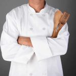 Cancer-Causing Chemicals Lurking in Your BBQ A chef in a white uniform holding wooden cooking utensils with crossed arms