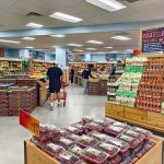 Inflation Guru Exposes America’s Failing System Interior of a grocery store with customers shopping for fresh produce