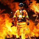 NASA’s Fiery Wildfire Breakthrough Firefighter standing in front of a large fire, equipped with tools