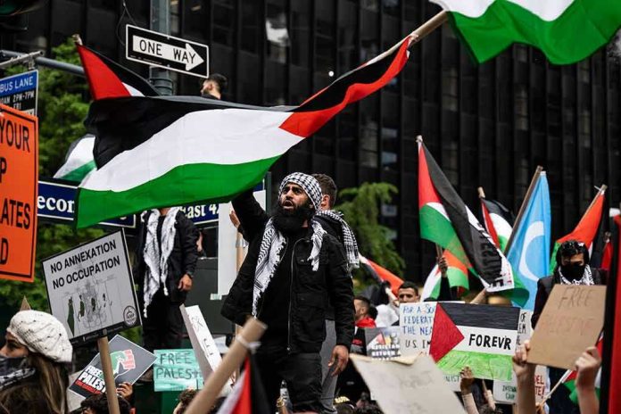 Protesters with flags and signs, one holding a megaphone.