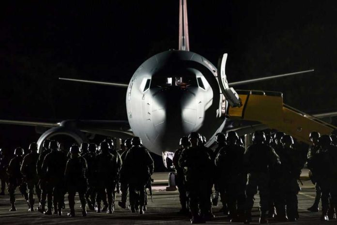 2407257831 Soldiers boarding aircraft at night with staircase
