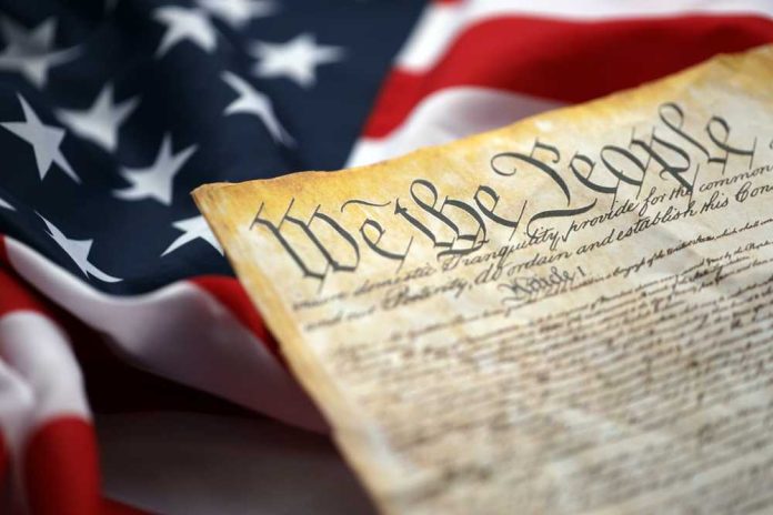 shutterstock_2636467319-1 Close-up of a historical document with the American flag in the background