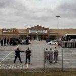 450 Years: Terror Plot Exposed Law enforcement officers and detainees outside a secure detention facility at a Walmart location