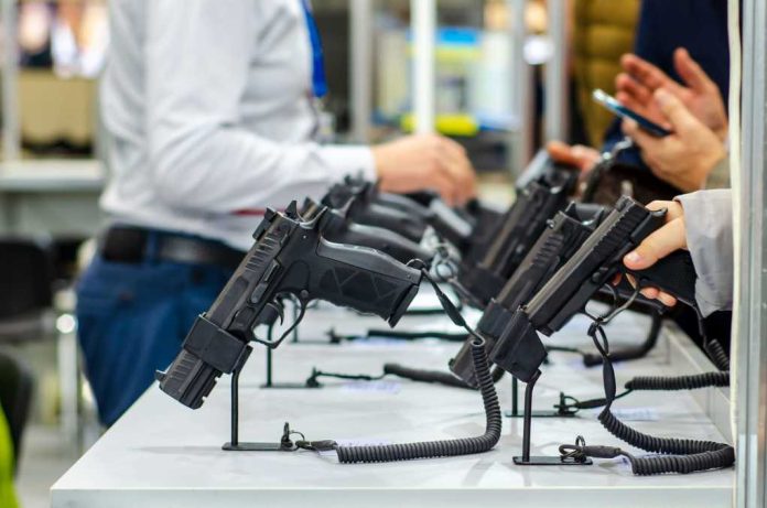 shutterstock1538947526jpg Display of handguns at a firearms exhibition with attendees interacting