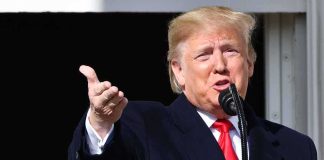 Hollywood Blast Targets Epstein Cover-Up man speaking at a microphone