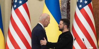 Two men shake hands at a podium with U.S. and Ukrainian flags