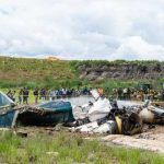 Wreckage of a crashed airplane with emergency responders and onlookers