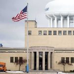 FBI Probes Iran Link to Water Chaos In U.S. Water treatment plant with US flag and large white water tower