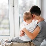 Father and 22-Month-Old Son Vanish During Afternoon Walk two children hugging by a window
