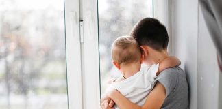 Father and 22-Month-Old Son Vanish During Afternoon Walk two children hugging by a window