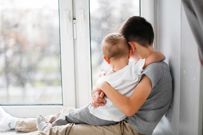 shutterstock_1627388638 two children hugging by a window