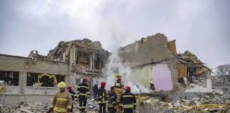 Firefighters search rubble of a partially collapsed building