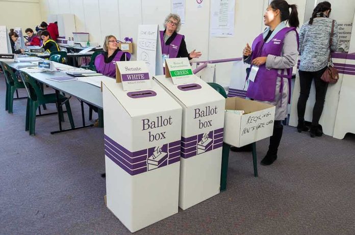 Election workers near ballot boxes in a polling station