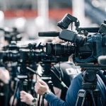 Parents Could Get $9,000 to Stay Home With Their Kids Broadcast cameras on tripods at a press event