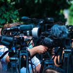 DHS Rule Would Deny Birthright Citizenship to Children of Foreign Government Employees TV news cameras crowding together at an outdoor event