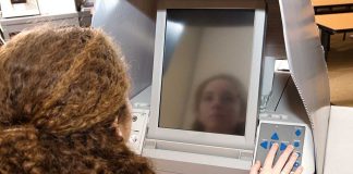 A person using an electronic voting machine at a polling station