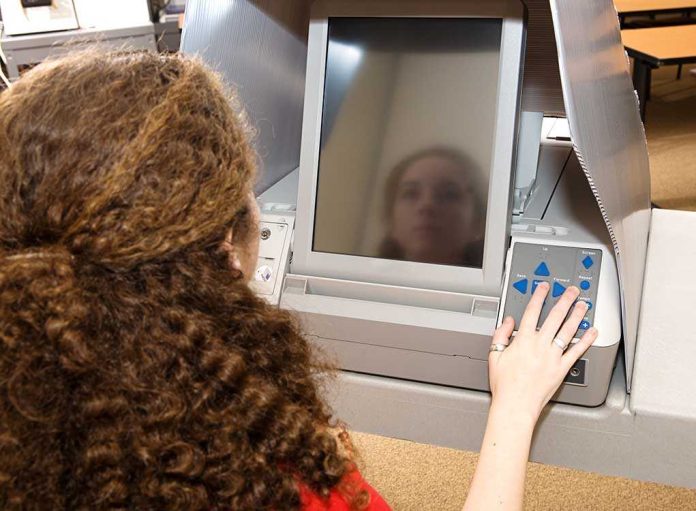 A person using an electronic voting machine at a polling station