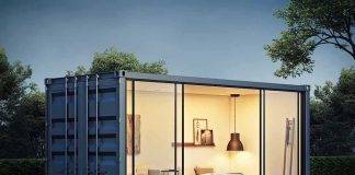 shipping container home with glass walls at dusk