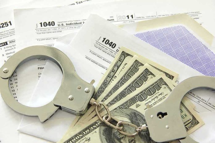 shutterstock_106939859 Handcuffs on tax forms with cash